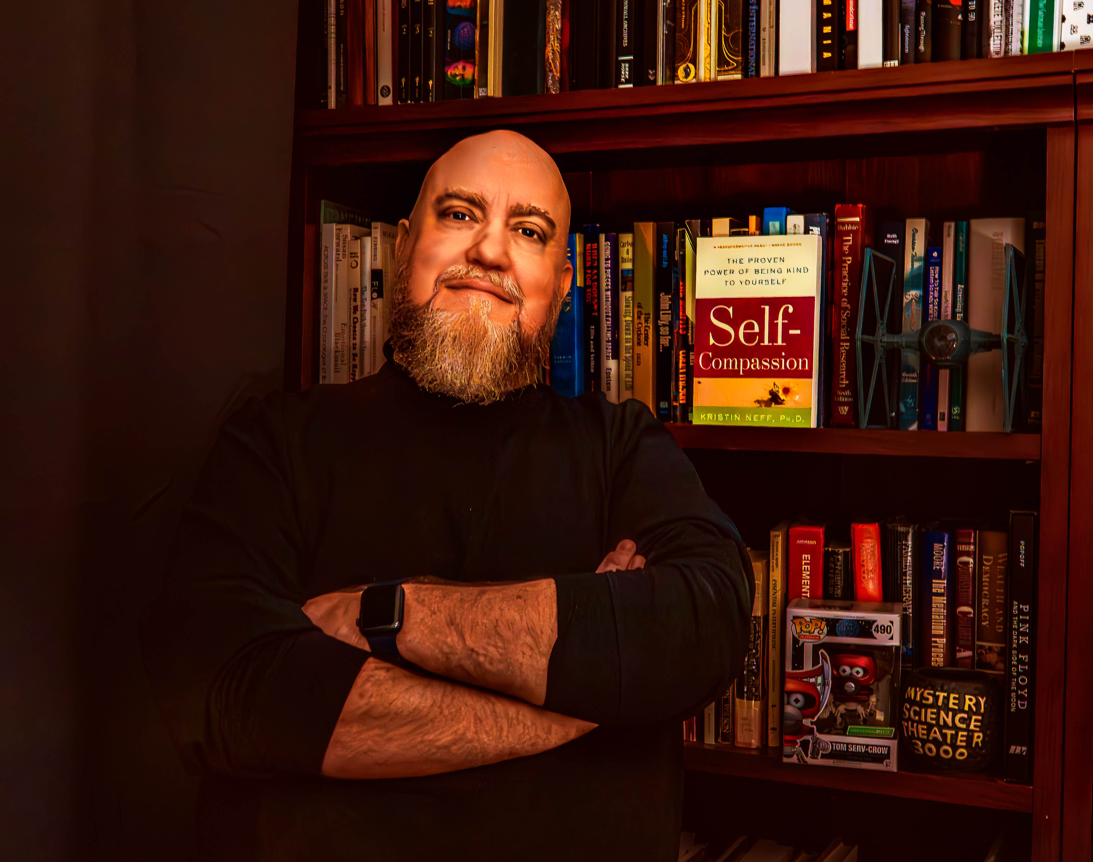Jason Joseph, therapist at Pattern Shift Counseling, standing in front of bookshelves
