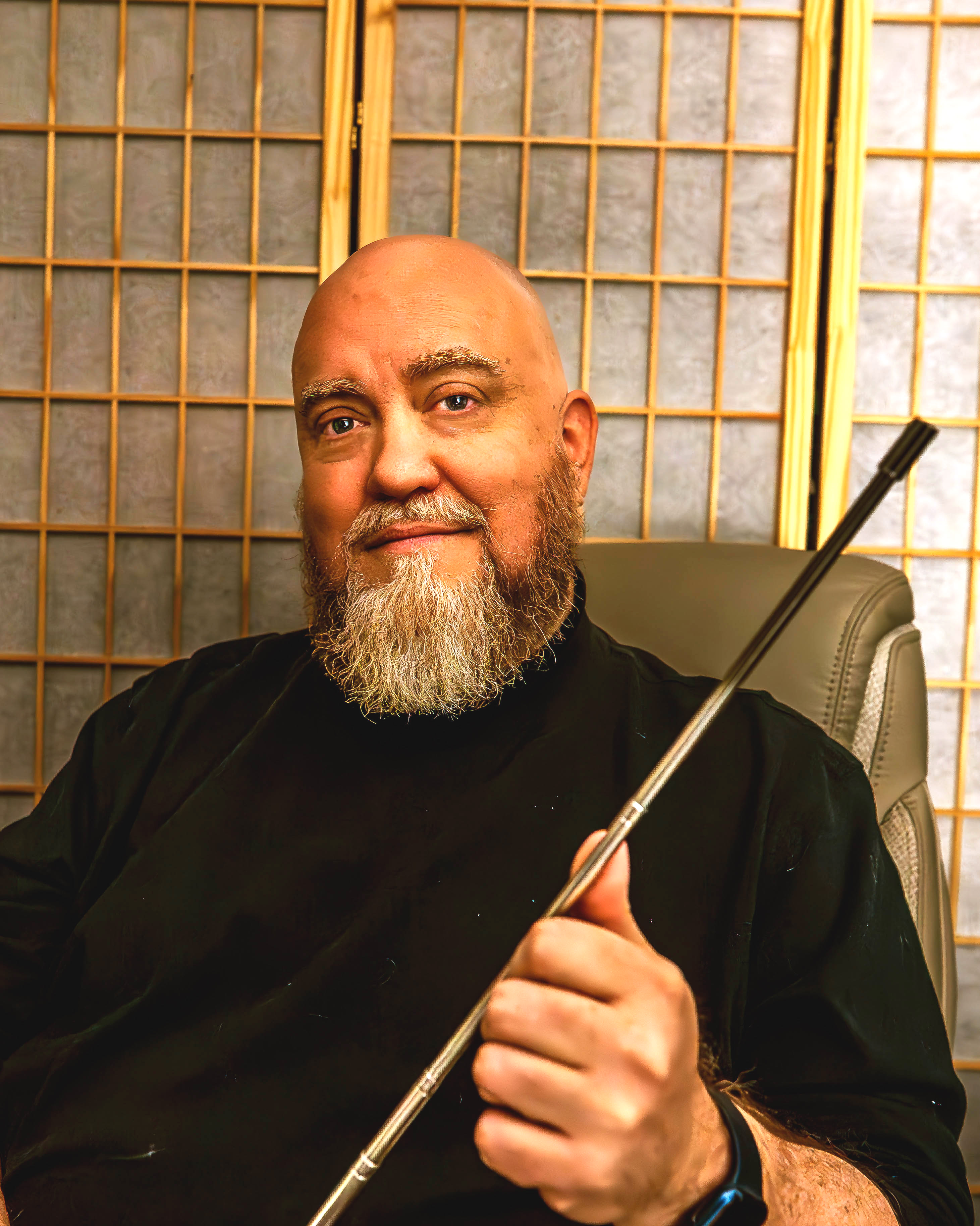 Jason Joseph, licensed therapist, holding a brainspotting pointer used in trauma-focused virtual therapy sessions