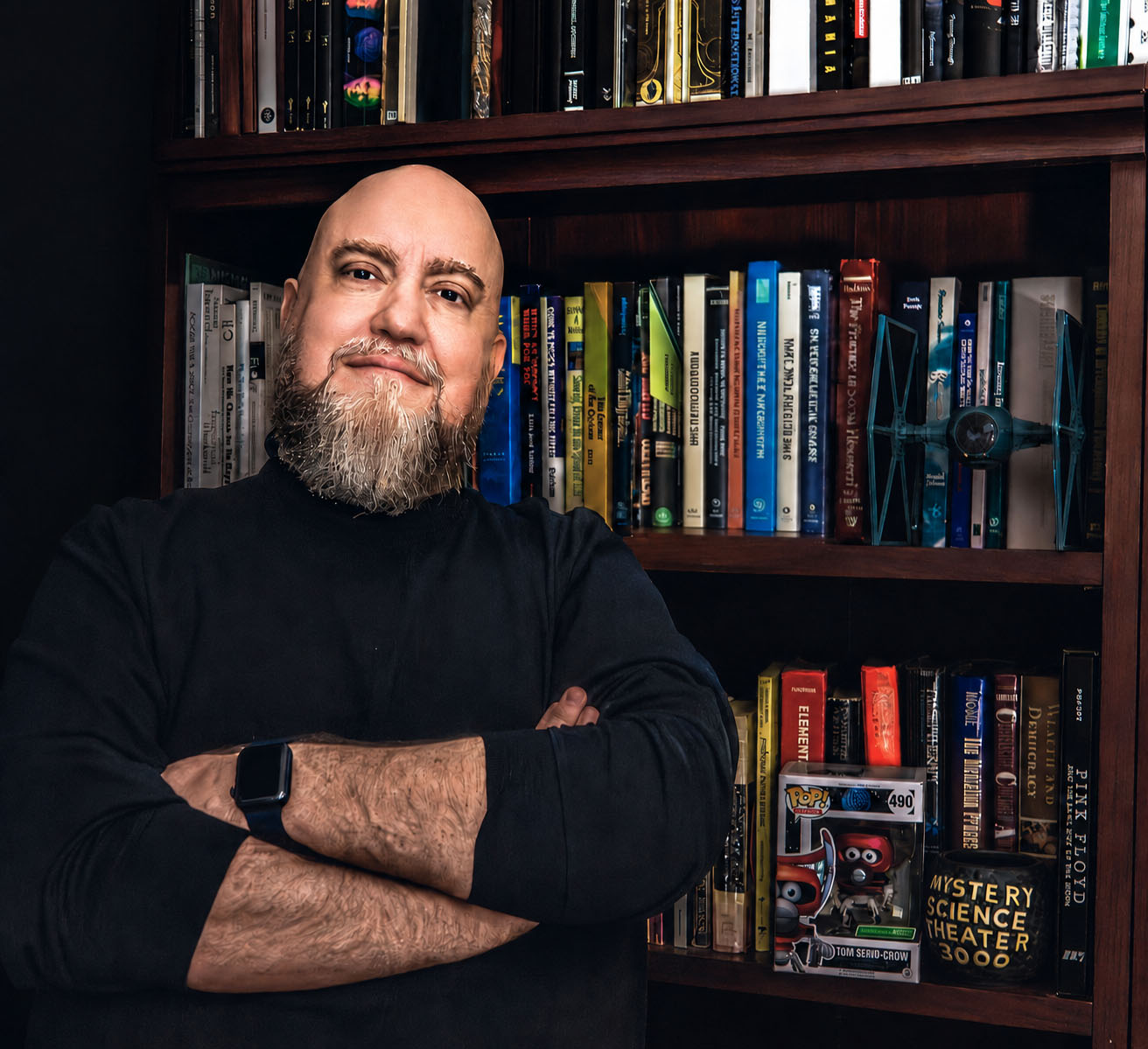 Jason in front of a bookshelf with psychology books and a few Star Wars and Mystery Science Theater 3000 collectibles